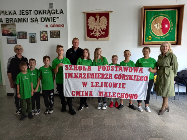 Uczniowie Z SP Lejkowo wraz z opiekunami i Panią Dyrektor oraz transparentem przygotowanym na mecz Polska - Holandia